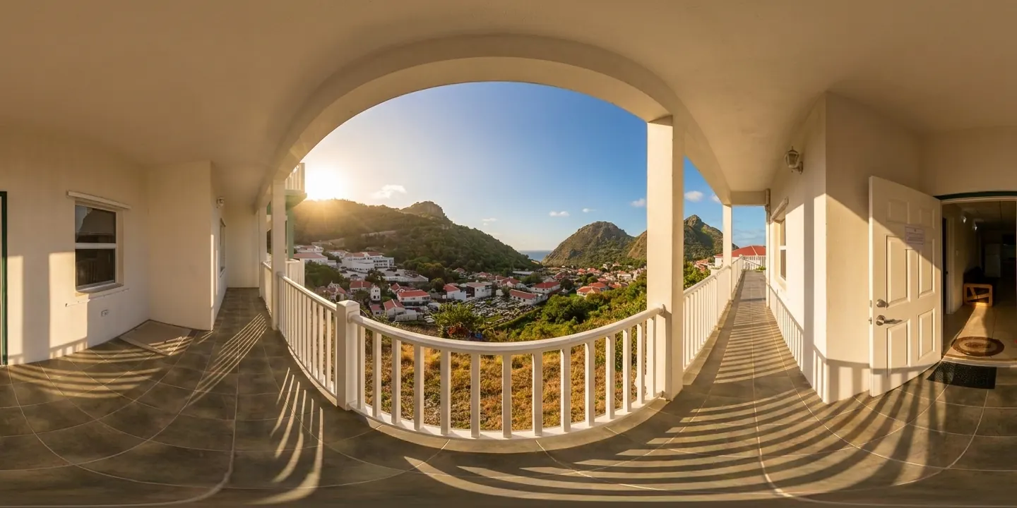 The balcony walkway of a Hillside building, looking out over the village