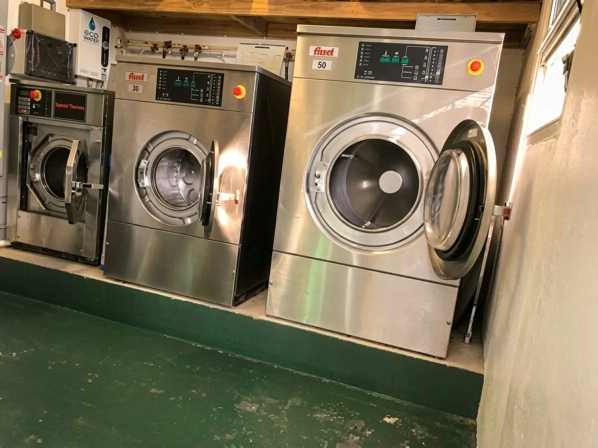 Two large commercial washing machines in the laundry room