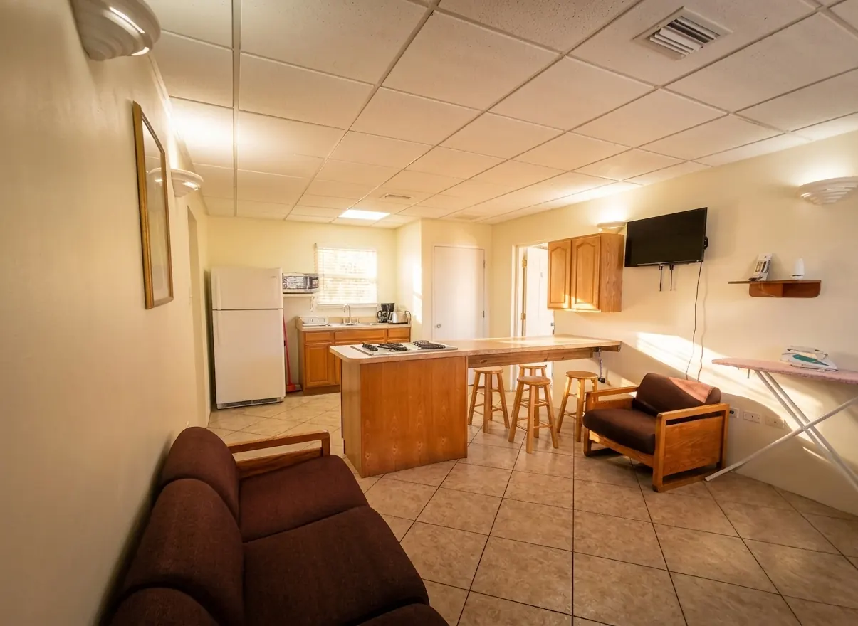 The shared living area with a sofa, a full size fridge and a kitchen counter beyond